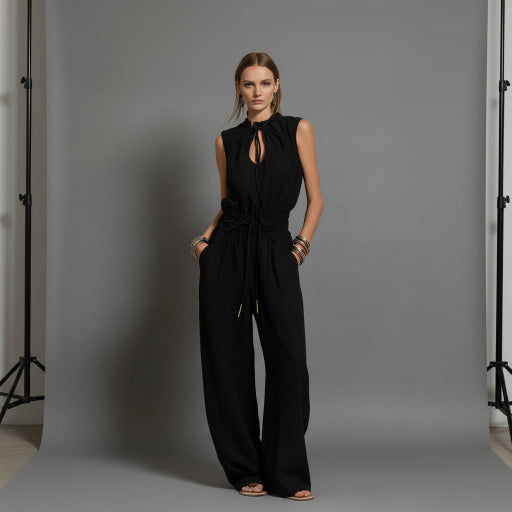 Black jumpsuit worn by a model on a gray background