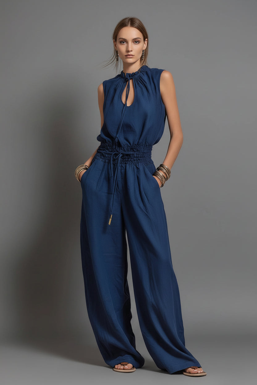 Woman wearing a blue jumpsuit against a gray background