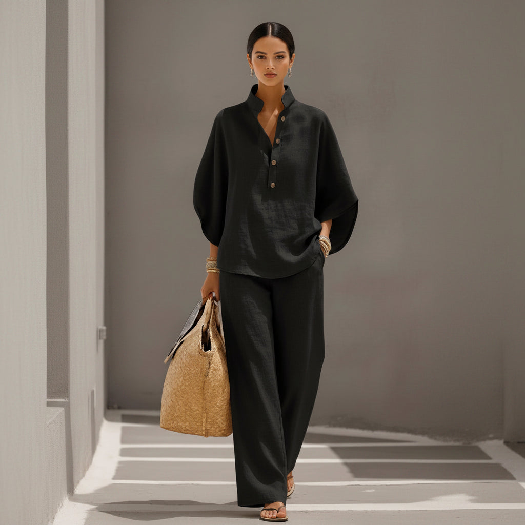 Person wearing a dark outfit holding a woven bag on a neutral background