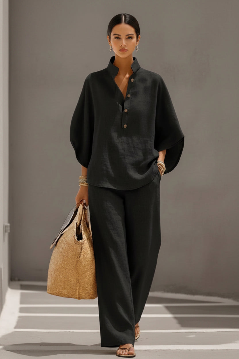 Person wearing a dark outfit holding a woven bag on a neutral background
