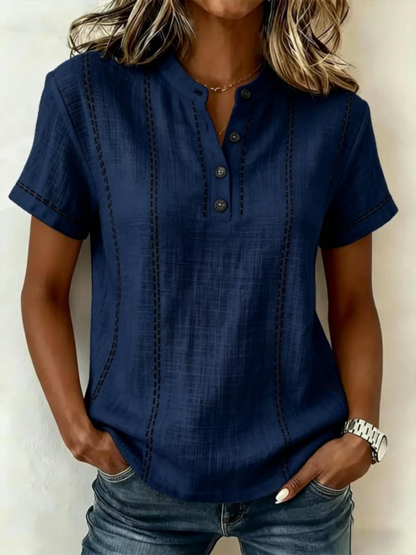 Woman wearing a blue short-sleeve blouse with a neutral background
