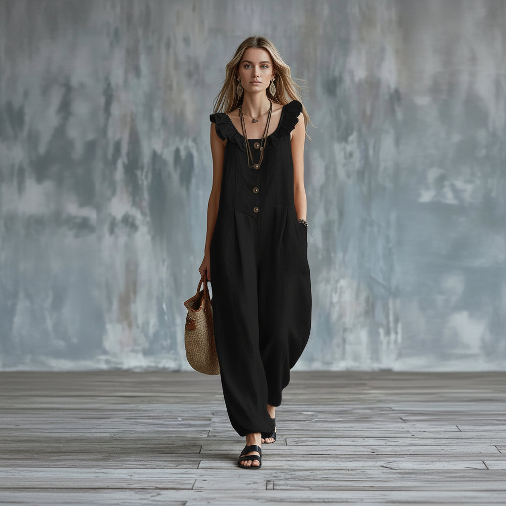 Woman wearing a black dress with ruffled sleeves against a textured wall.