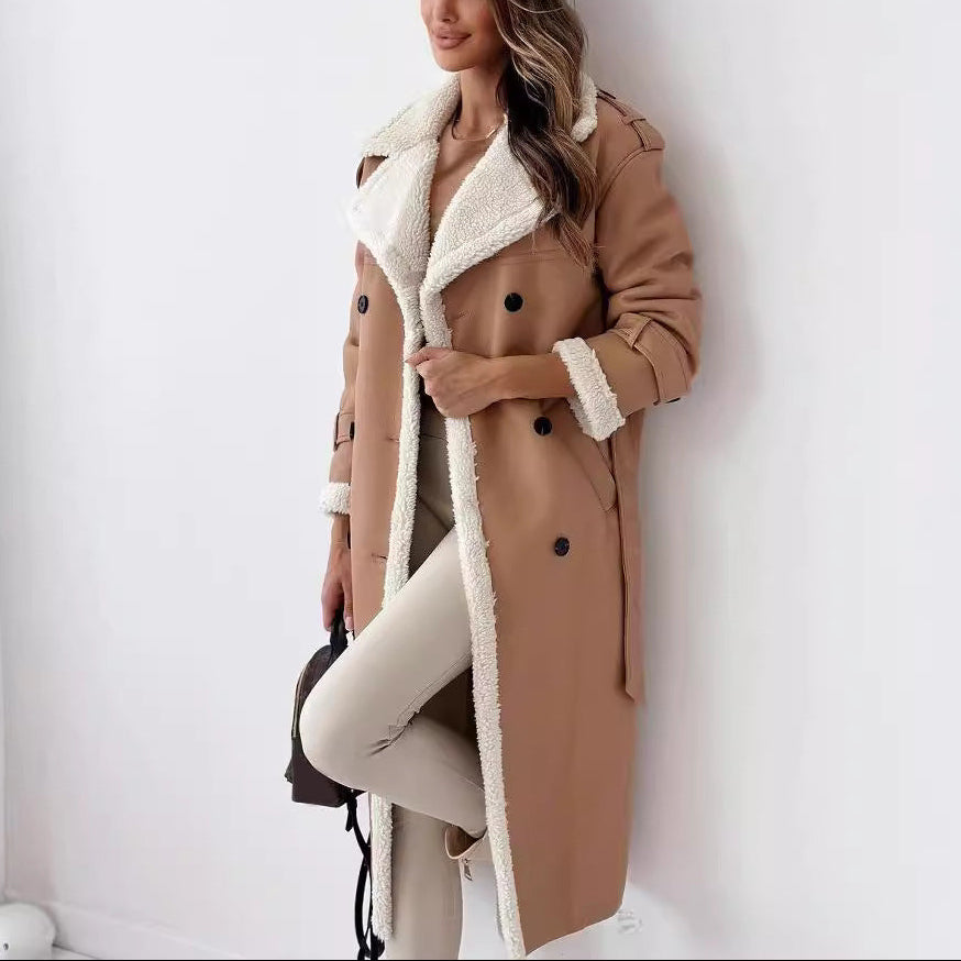 Woman wearing a tan coat with white fur lining against a white wall