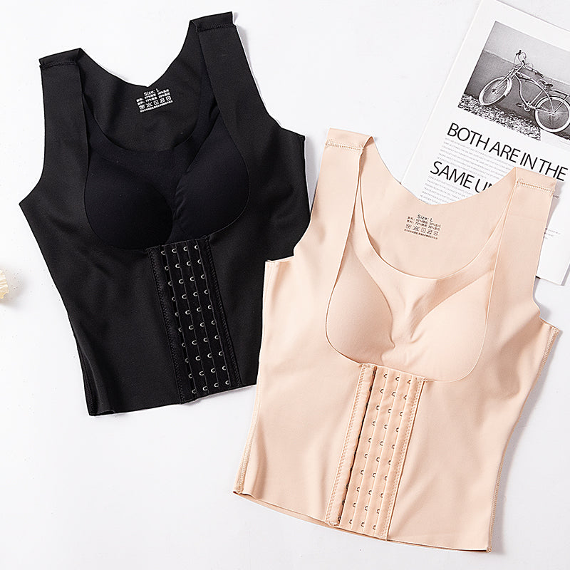 Black and beige waist training corsets on a white surface with a magazine underneath.