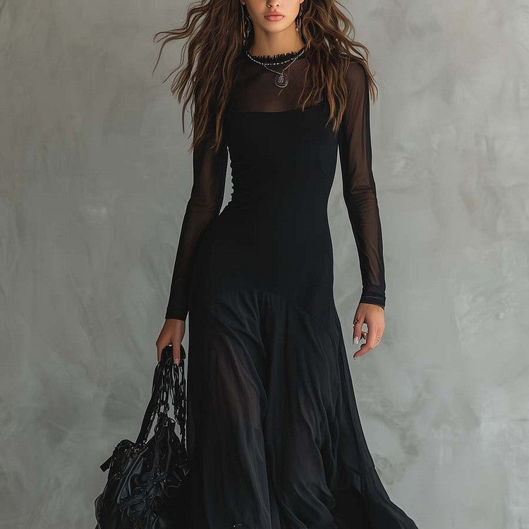 Person wearing a long black dress with sheer sleeves against a gray background