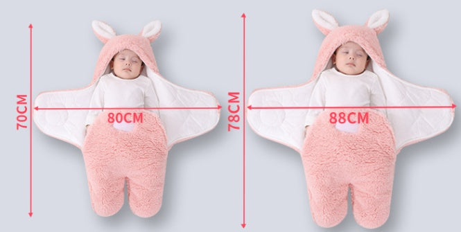 Baby in a pink bunny costume with measurements on a light gray background