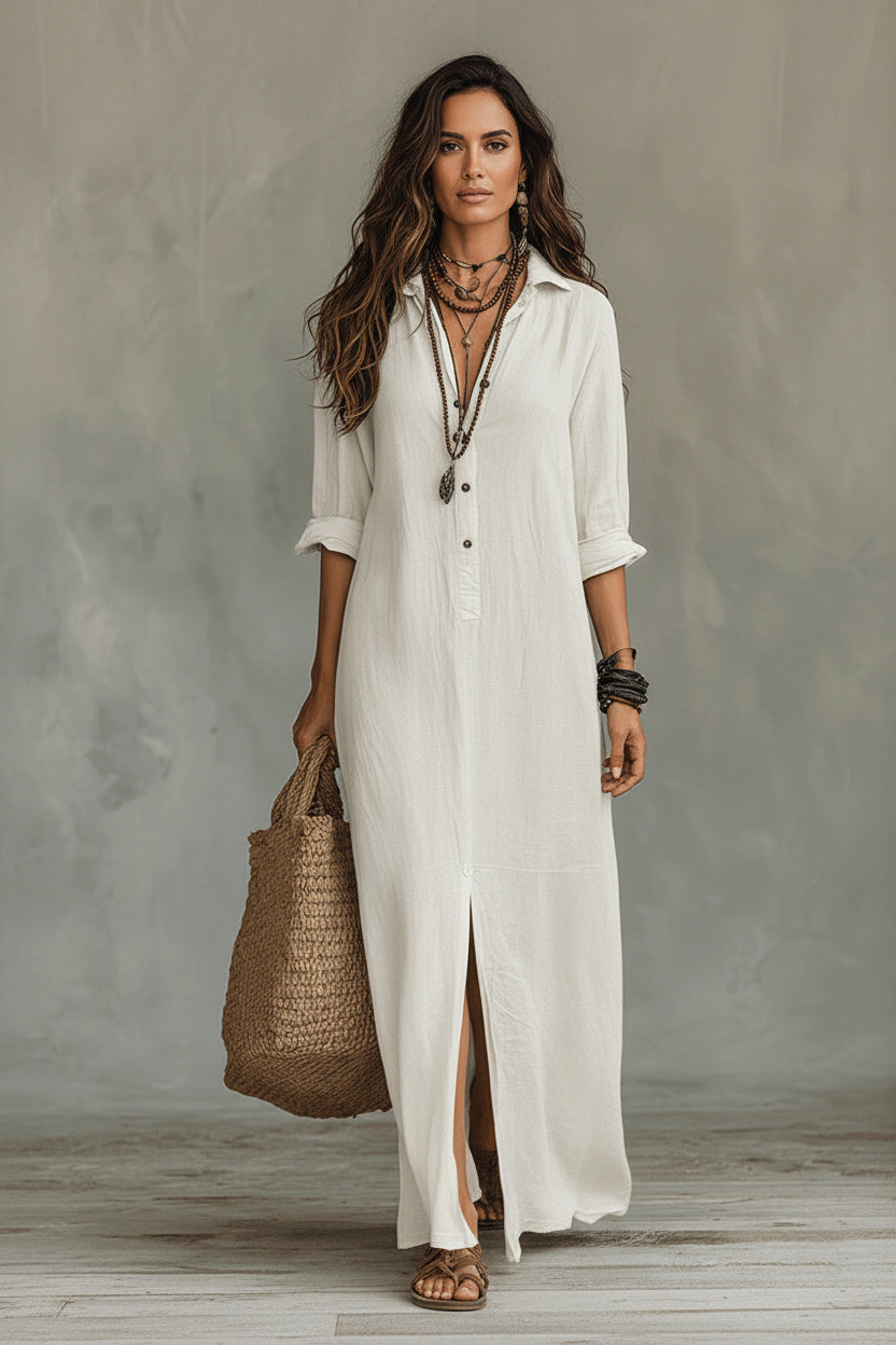 Woman wearing a long white shirt dress holding a woven bag against a neutral background
