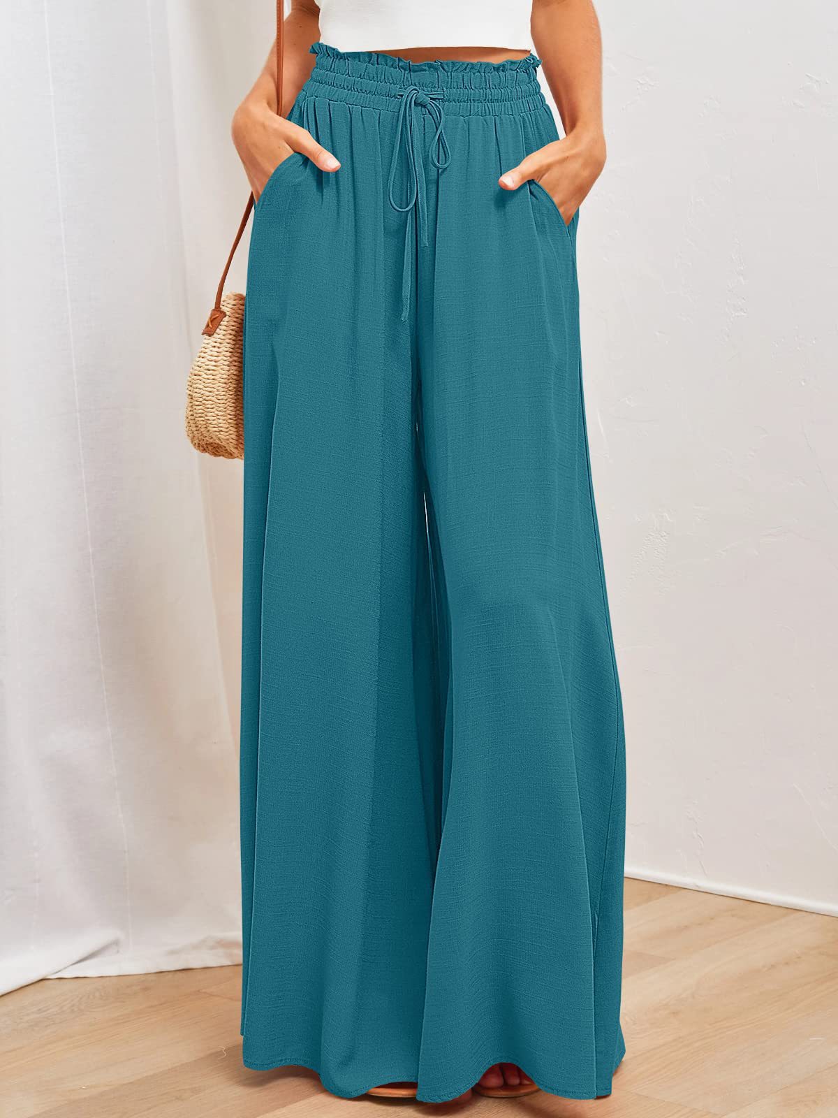 Teal wide-leg pants worn by a person on a white background