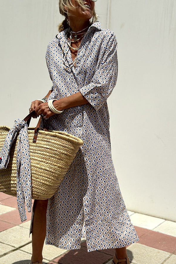 Woman in a polka dot dress holding a straw bag against a plain background