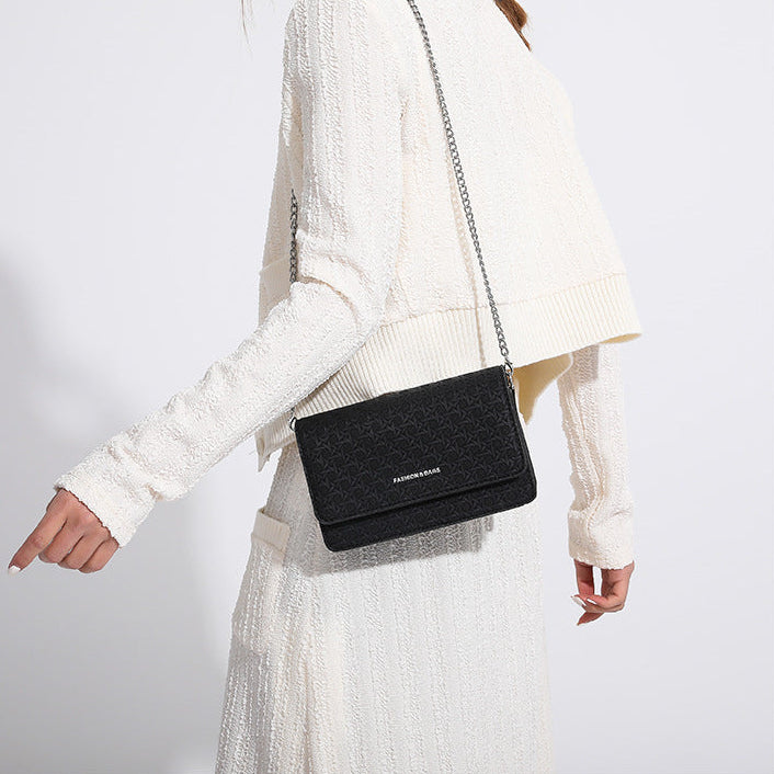 Person wearing a black handbag with a white background