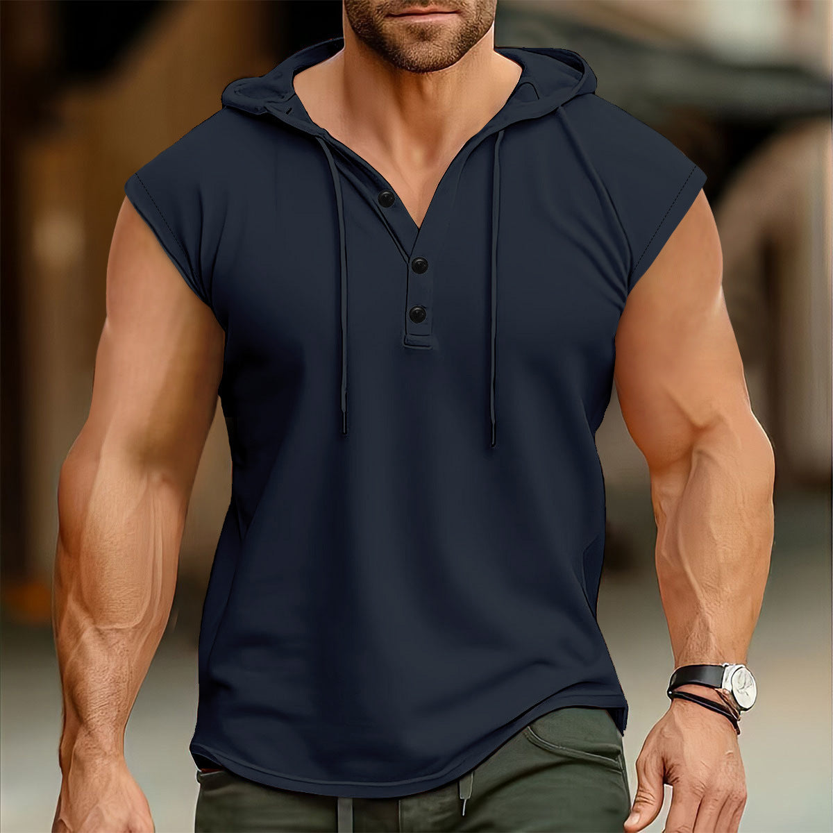 Man wearing a navy sleeveless hoodie with a blurred background