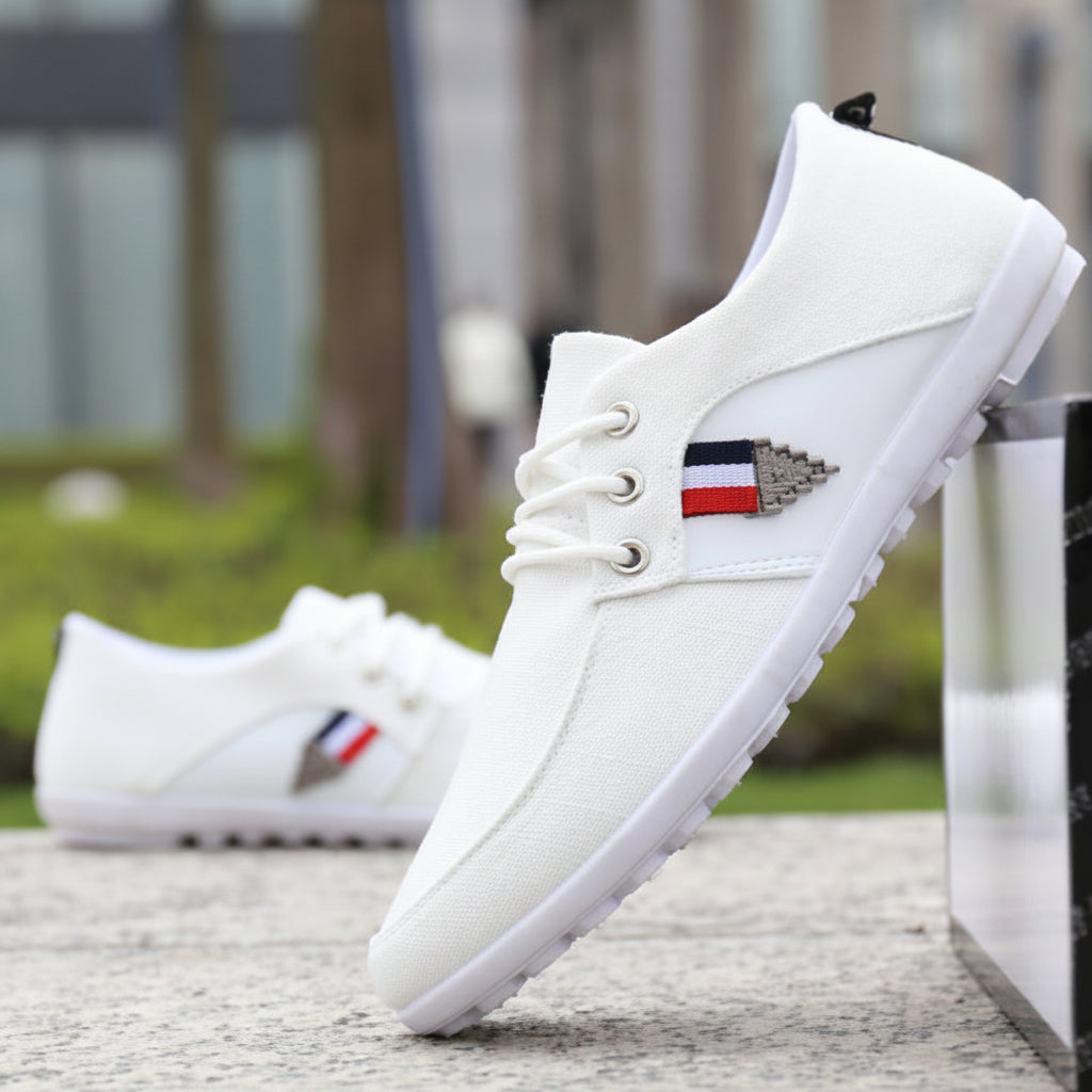 White sneakers with a brand logo on a blurred outdoor background