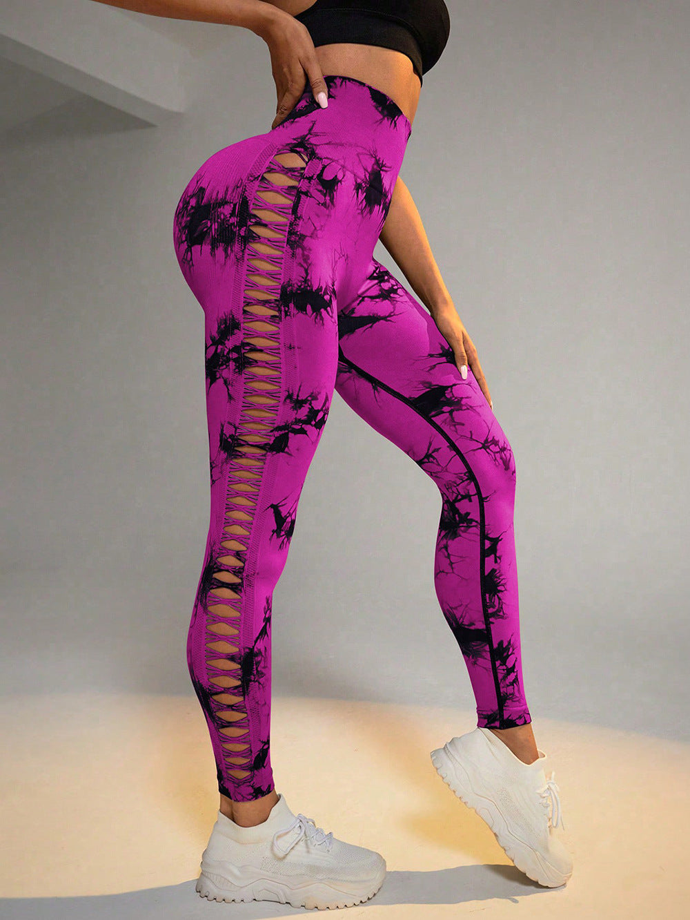 Person wearing pink leggings with black tie-dye design on a neutral background