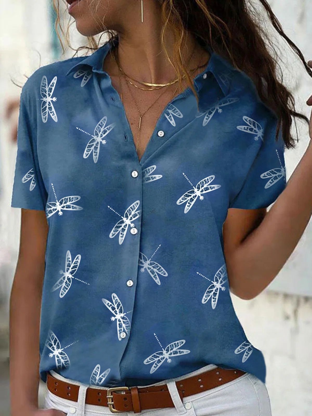 Woman wearing a blue shirt with white dragonfly patterns.