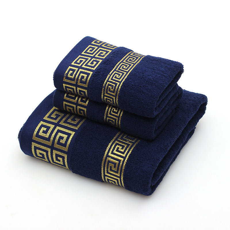 Two navy blue towels with gold geometric patterns on a white background
