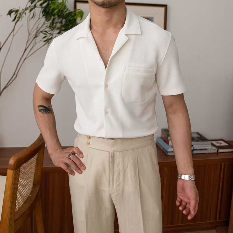 Man wearing a white shirt and beige pants in an indoor setting