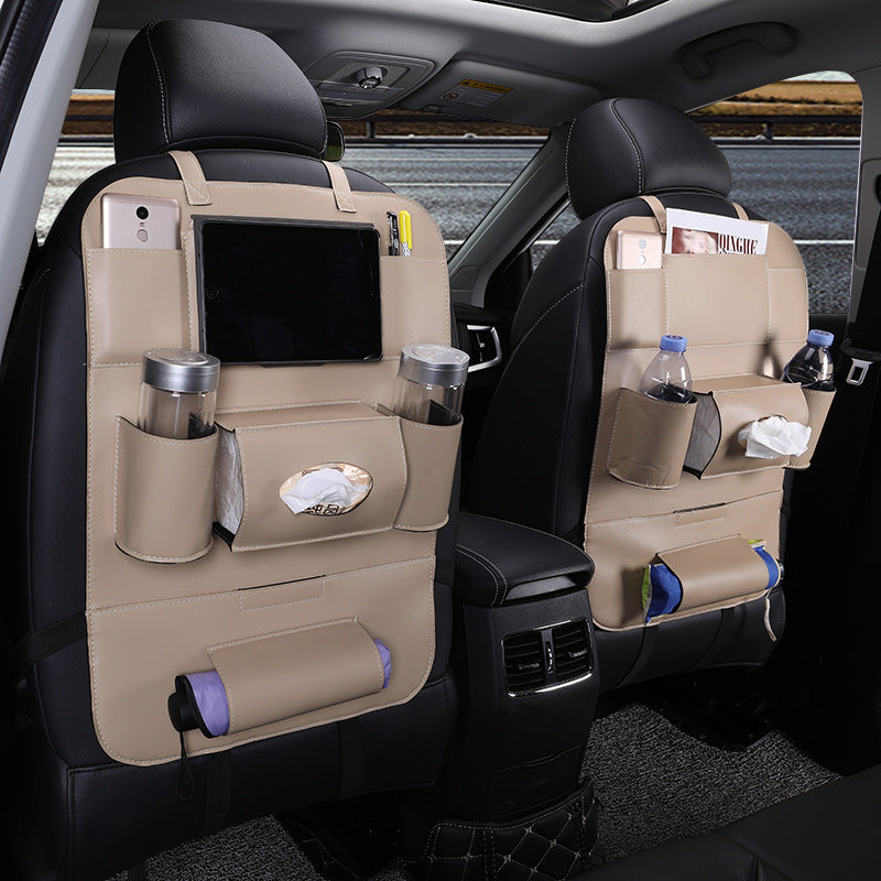 Car back seat organizer with multiple pockets and items inside a vehicle.