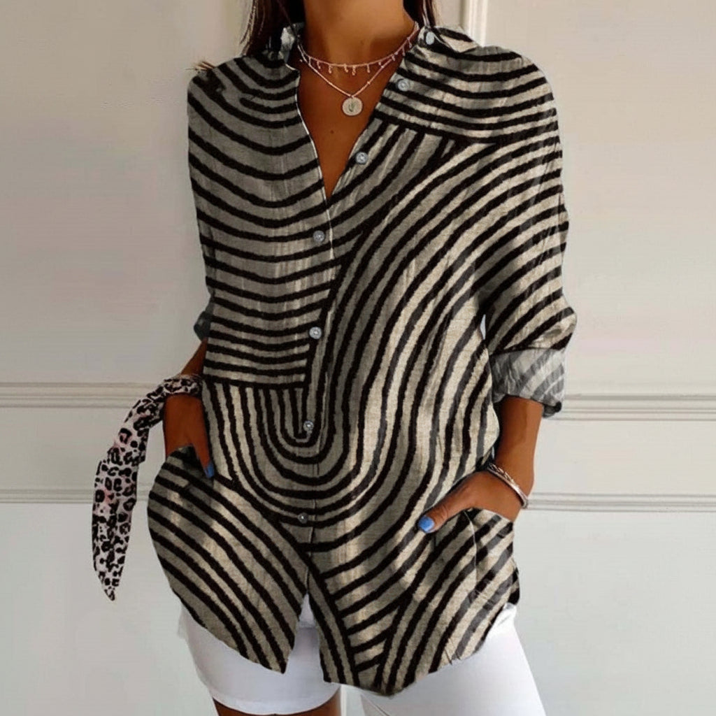 Woman wearing a black and white striped outfit with a leopard print bag.