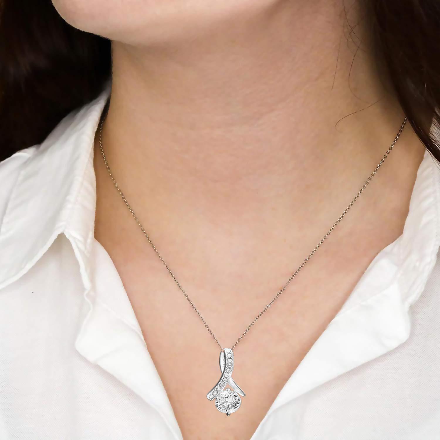 Silver necklace with a pendant worn by a person against a white shirt background