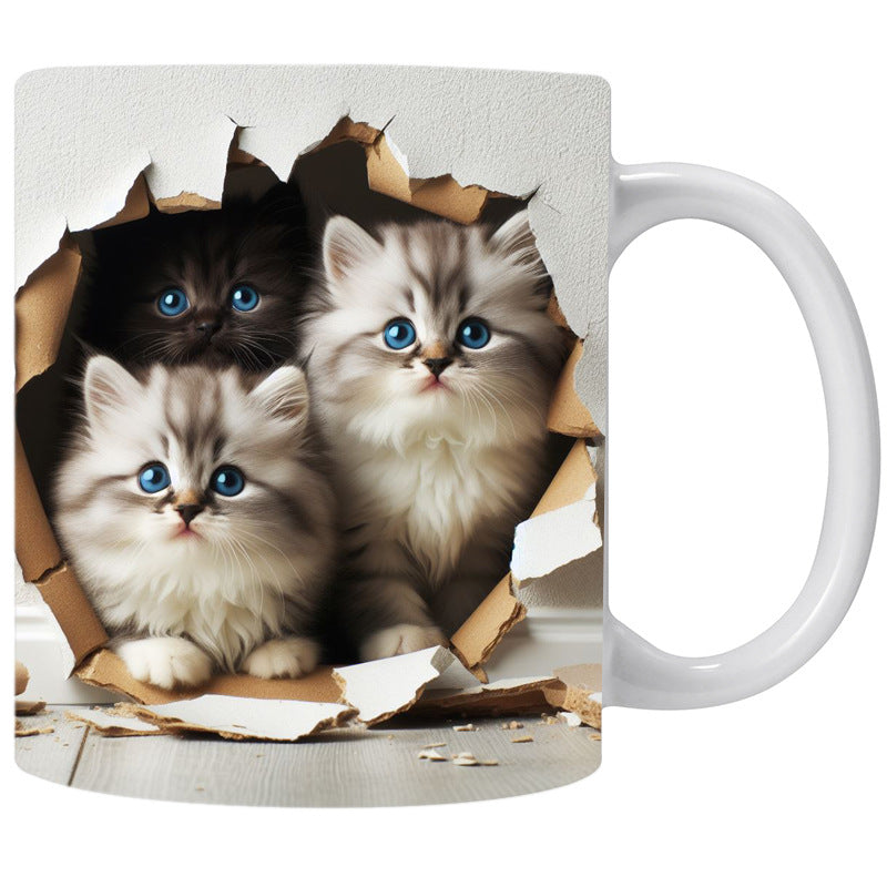 Mug with three kittens peeking through a cardboard hole on a white background