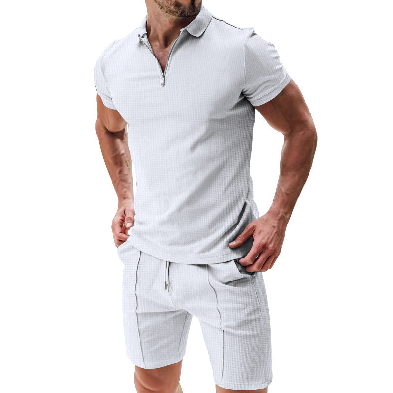 Man wearing a light gray polo shirt and shorts set on a white background