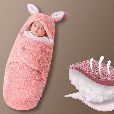 Newborn baby wrapped in a pink bunny costume with a brown background