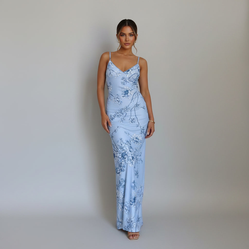 Woman wearing a blue floral dress against a white wall