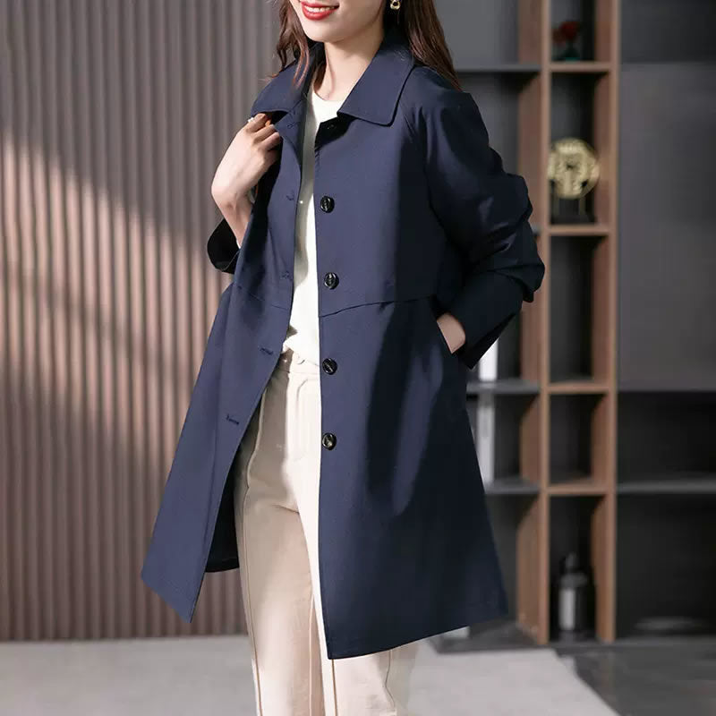 Person wearing a navy blue coat in an indoor setting