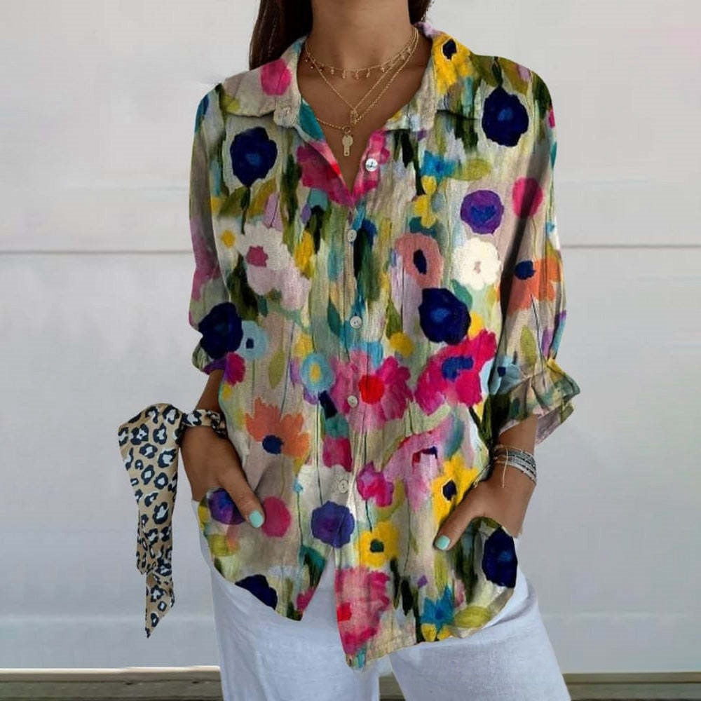 Colorful floral blouse worn by a person against a white background