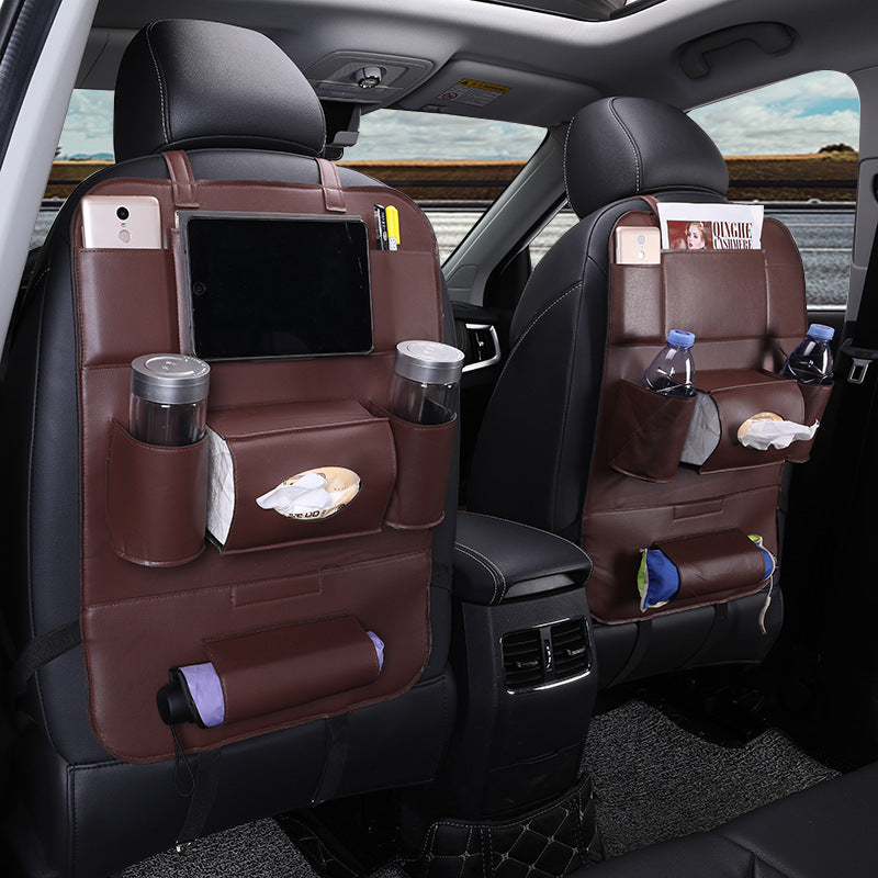 Car interior with brown leather seat covers and various items on the backrests.
