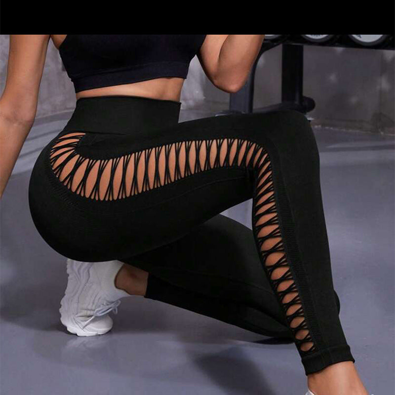 Black leggings with cut-out design worn by a person on a gray background