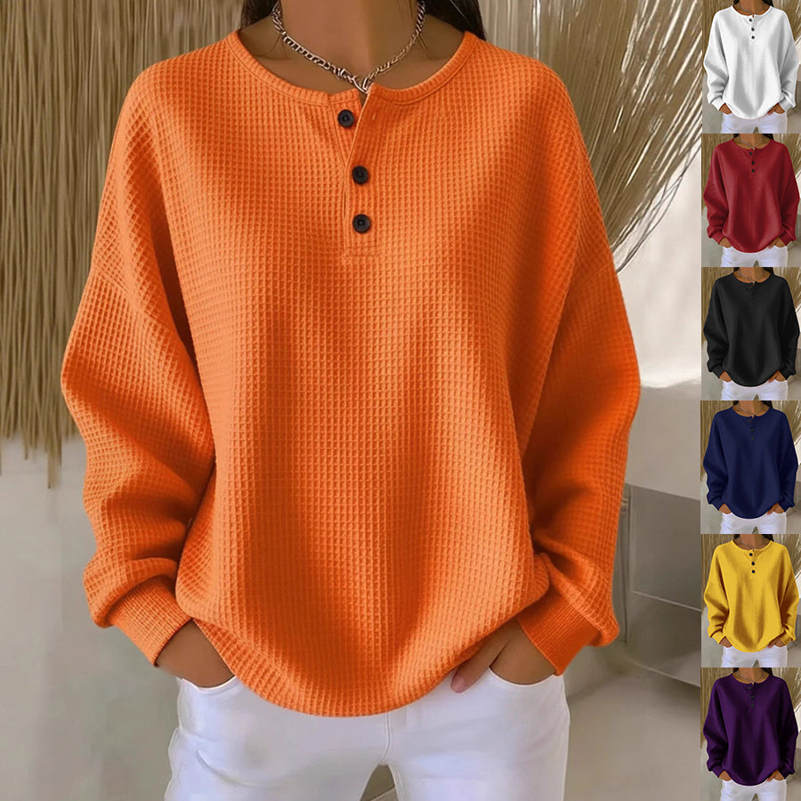 Orange textured long-sleeve shirt with buttons worn by a person against a neutral background
