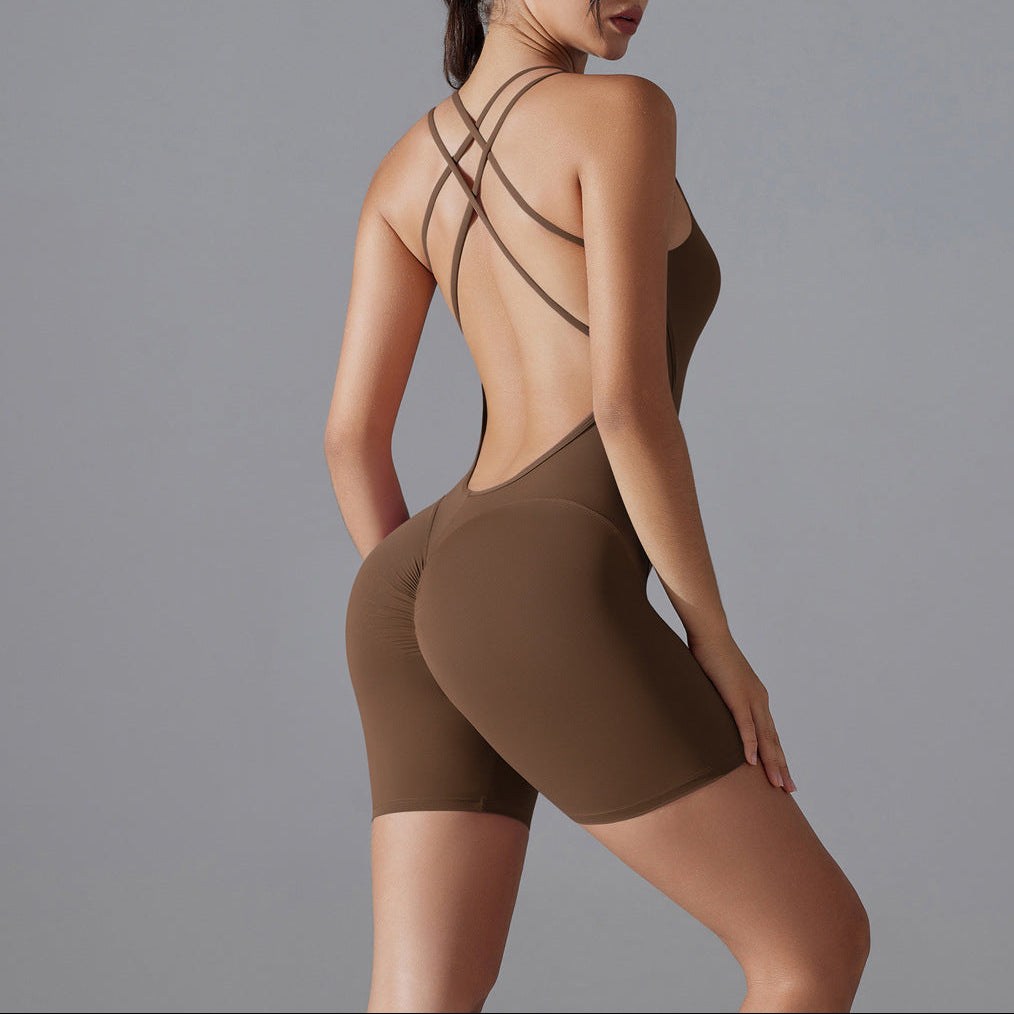 Woman wearing a brown bodysuit with criss-cross straps on a gray background