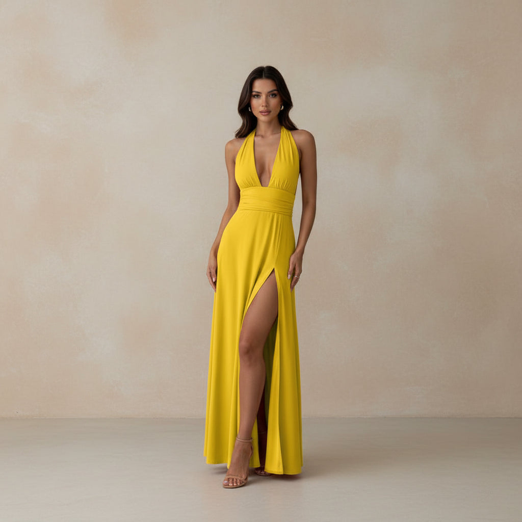 Woman wearing a yellow dress with a high slit, standing outdoors.