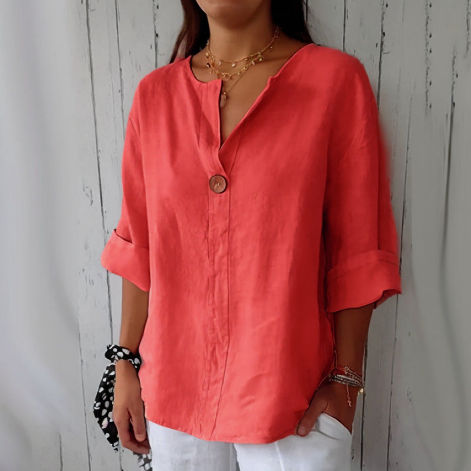 Person wearing a coral-colored shirt with a wooden background