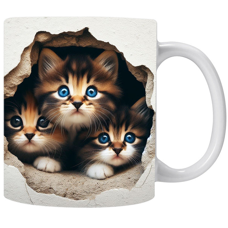 Mug with a design of three kittens peeking through a hole in the sand.