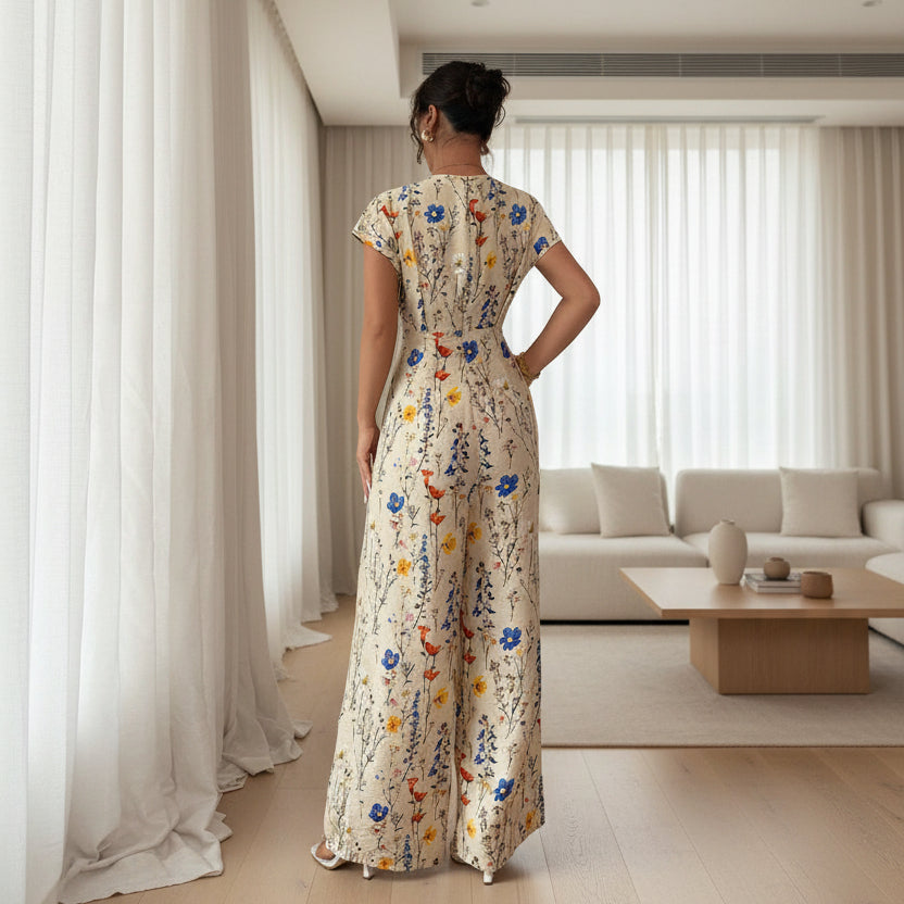 Woman wearing a floral dress standing in a room with white curtains and gray floor.