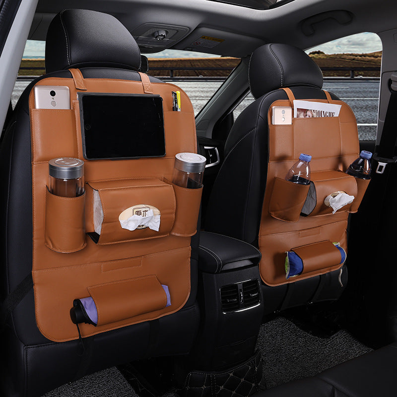 Car interior with brown seat covers and storage pockets, showing a road trip setting.