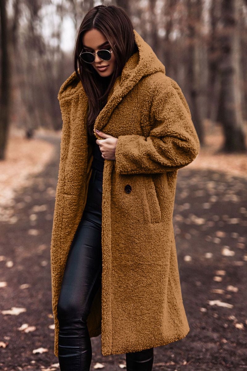 Woman wearing a brown coat in a forest setting