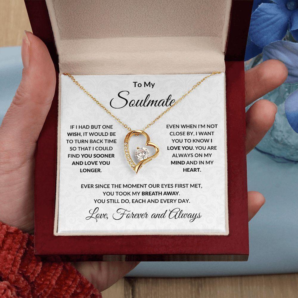 Necklace with heart-shaped pendant and sentimental card held in a hand