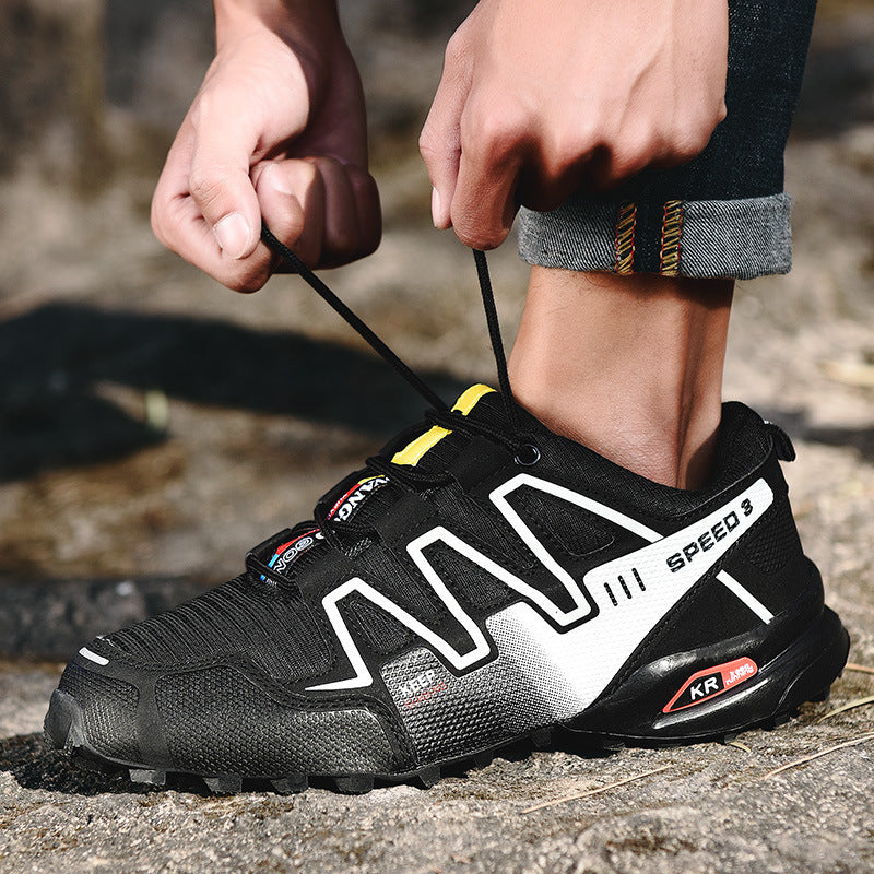 Person tying a black and white sneaker with visible branding on a natural background