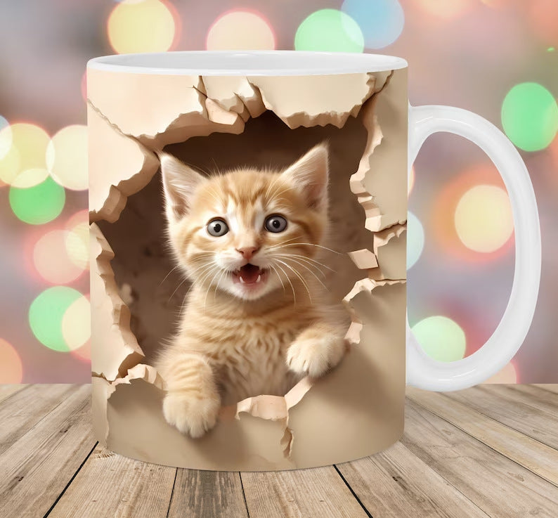 Mug with a design of a kitten peering through a cardboard box, set against a blurred background with colorful lights.