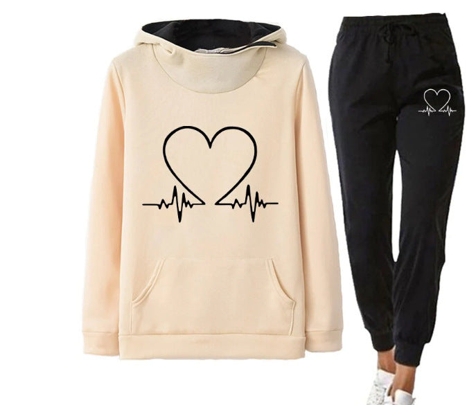 Beige hoodie and black jogger pants with heart design on a white background