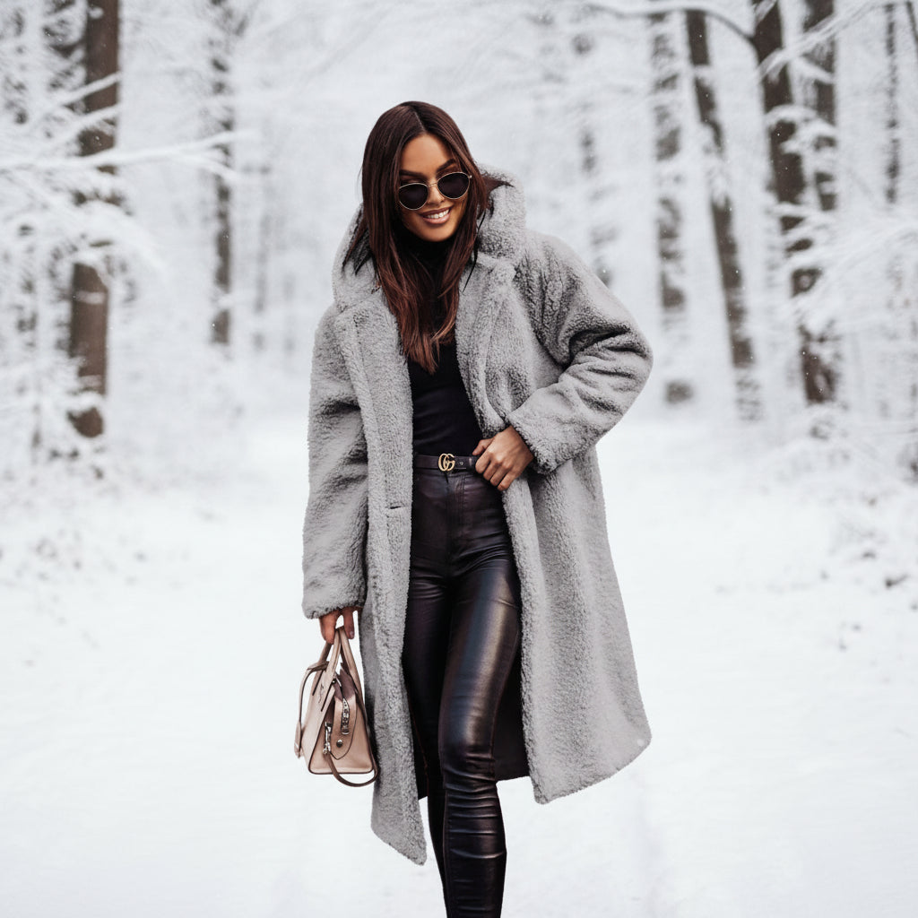 Woman wearing a long gray coat in a forest setting